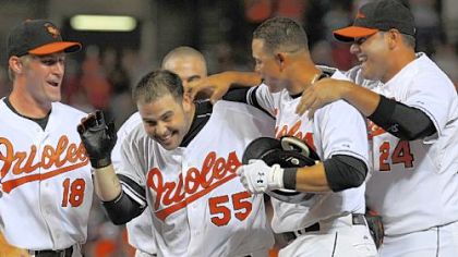 The Orioles' Ramon Hernandez (55) is surrounded by teammates after driving in the winning run against Pirates in the ninth inning last night in Baltimore.