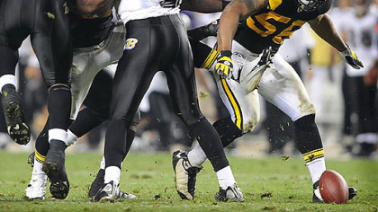 LaMarr Woodley picks up a fumble that he returns for a touchdown against the Ravens in the third quarter last night at Heinz Field.