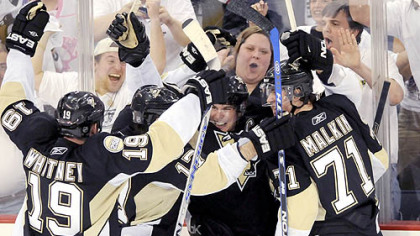 The Penguins celebrate the winning third-period goal.
