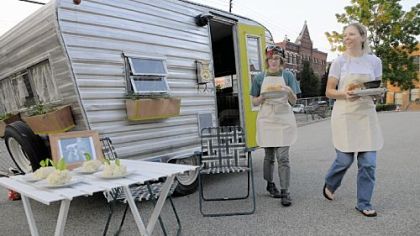 Laura Miller and Dawn Weleski clean up after serving dinner for Allen Benson Saturday in their RV Eatin' mobile cafe in Lawrenceville.