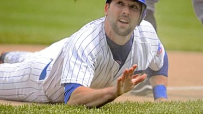 The Cubs' Mark DeRosa looks up at umpire Jim Wolf after sliding safely into third base against the Pirates in the third inning yesterday.