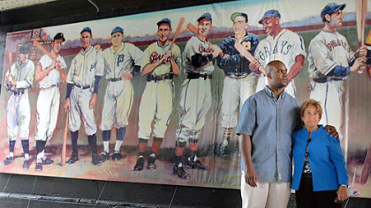 Sean L. Gibson, great-grandson of baseball player Josh Gibson, stands with Judy O'Connor, widow of late Mayor Bob O'Connor, during the dedication of the new "legends of Pittsburgh" baseball mural on Ross Street.  Josh Gibson is painted right above Sean.