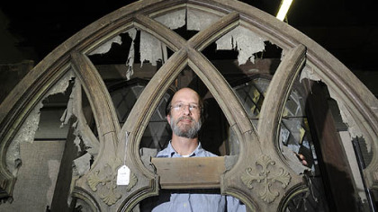 David Arnold, consignment manager at Dargate Auction Galleries, looks through a wooden lancet tracery panel that screened a church's pipe organ, once part of Vernon Regal's collection.
