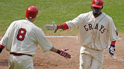 Washington Cristian Guzman, right, scores in the sixth inning. It was part of a day in which he went 4 for 5 with a home run and six RBIs in the Nationals' 9-8 victory.