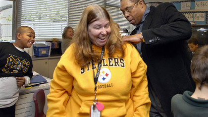 Dwight White signs teacher Marlene Berncic's sweatshirt during a visit to Pace School in Churchill.  The school  held a ceremony to thank the former Steeler for his support of the institution.