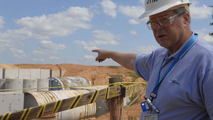 Jim Latham, vice president of Barnwell operations of Energy Solutions, points to waste secured inside steel drums, encased in concrete vaults in an uncapped trench at Energy Solutions in Barnwell, S.C.