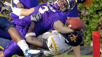 East Carolina's Jonathan Williams tries to stretch into the end zone over West Virginia's John Holmes in the first half of their game yesterday in Greenville, N.C.