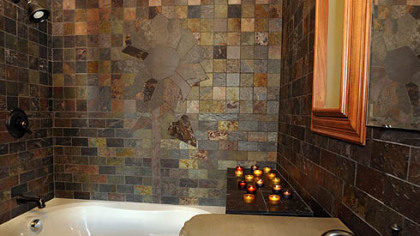 The master bath features a slate shower with a giant mosaic flower by tiler Jeff Kunst copied from the base of the vanity as a surprise for Mrs. Stephany.