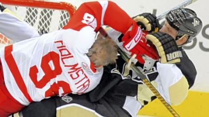 Gary Roberts, right, clears Detroit's Tomas Holmstrom from in front of the net in the first period last night.