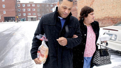 Ellwood City Police Chief Richard McDonald helps Doreen Welsh walk through an icy parking lot in downtown Ellwood City on Tuesday.