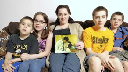 Children of Sandee McCann in Georgia: From left,  Chris Gebert, Bria Gebert, Alexandra Firestone (holding a photo of her mother and father), Dylan Gebert and Jude Gebert.
