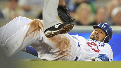 Dodgers right fielder Matt Kemp ducks under the tag of the Pirates' third baseman Jose Bautista between second and third base as he is caught in a rundown during the first inning of last night's baseball game, in Los Angeles. Kemp made it safely to third on the play.
