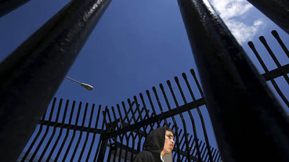 TIJUANA -- A youth stands next to a gate at the border awaiting his deportation to Tijuana, Mexico. More than 700 Mexicans are expelled from the U.S. through this gate daily.