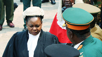 LUSAKA, Zambia --  First Lady Maureen Mwanawasa, foreground, and Chief Justice Enerst Sakala leave the Supreme Court after honoring her husband who died Tuesday. President Levy Mwamnawasa had battled poor health for years.