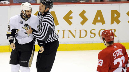 The Penguins' Maxime Talbot has words with the Red Wings' Brad Stuart as he's taken off for a penalty.