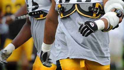 Steelers lineman Chris Kemoeatu returns to workouts with a large brace on his left triceps for the afternoon practice yesterday at Saint Vincent College in Latrobe.