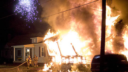 Sparks fly from two crossed power lines as firefighters confront the raging fire in Brockway in which at least eight people were killed.