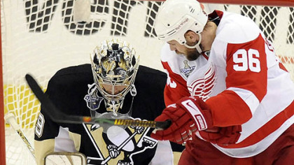 The Penguins' Marc-Andre Fleury makes a save on the Red Wings' Tomas Holmstrom in the first period.
