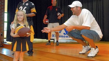 Wyland kindergartener Jessica Leventry receives an autographed football from Ben Roethlisberger. Jessica, won a raffle for the ball.