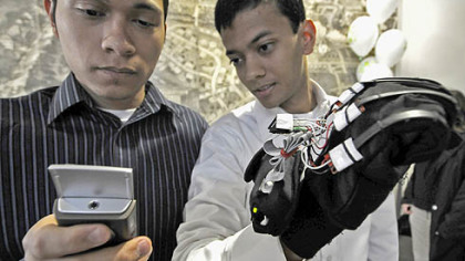 Hemant Sikaria, right, and Jorge L. Meza use a cell phone to check on the status of the glove.