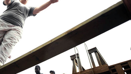 Slippery Rock freshman Angela Yocham, 18, reaches out for help while walking across a plank of wood between platforms during a team-building exercise last Wednesday.