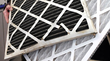Sol Gross, who is renovating 84 apartments in a building he owns at 625 Stanwix St., Downtown, holds a new air filter and a dirty one from the Avis car rental office on the ground floor of his building.
