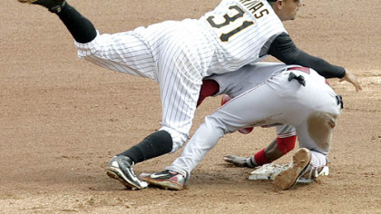 The Reds' Brandon Phillips rolls into Pirates shortstop Luis Rivas, who completes the throw to finish a double play on Jeff Keppinger in the eighth inning.