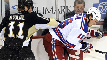 Penguins center Jordan Staal gets a hit along the boards on his brother, Marc Staal, in the second period.