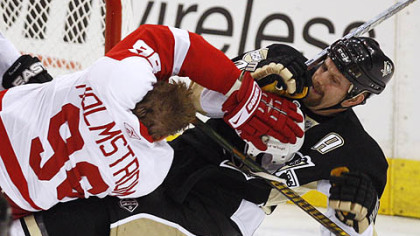 Detroit's Tomas Holmstrom, left, takes out Gary Roberts during first period action in Game 3 of the Stanley Cup Final at Mellon Arena.