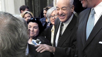 Former Coroner Dr. Cyril H. Wecht leaves the federal courthouse yesterday after a mistrial was declared in his case. At left is his wife, Sigrid.