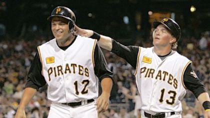Pirates' Nate McLouth, right, pats teammate Freddy Sanchez on the helmet after the two scored on a double by Ryan Doumit.