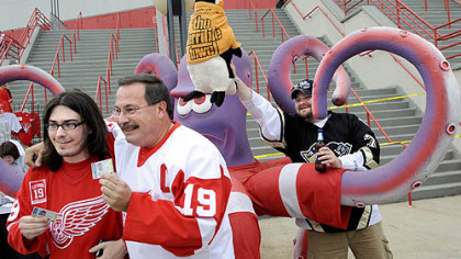 Red Wings fans Lee Lexa, 22, of Latrobe, and his dad, Rob, 53, get their photo taken in front of an Octopus outside Joe Louis Arena as Ryan Skomra, 27, of Portage, tries to ruin their moment.