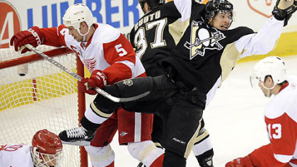 The Penguins' Sidney Crosby flies by Red Wings goalie Chris Osgood as he scores in the first period.