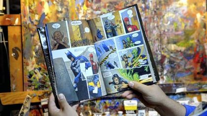 Christopher Moeller shows one of his novels for DC Comics, "JLA, A League of One."