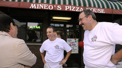 Mineo's Pizza House owners Jon, center, and Dominic Mineo, talk with city council president Doug Shields, left, during the 50th Anniversary event at the Squirrel Hill insitutution.