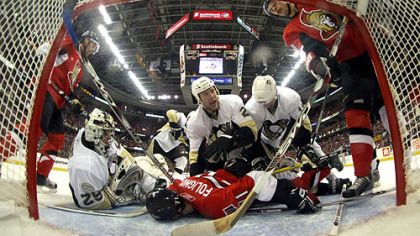 Ottawa's Nick Foligno absorbs the wrath of a host of Penguins in the Penguins' crease Monday in Game 3.