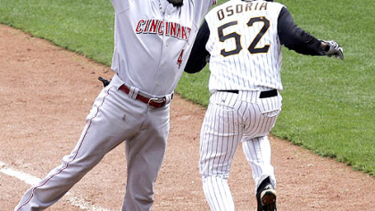 Cincinnati's Brandon Phillips can't get to the ball as Pirates pitcher Franquelis Osoria is safe at first on a bunt.