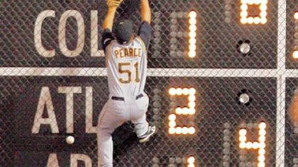Pirates right fielder Steve Pearce climbs the fence in vain to try and catch a ball hit by Philadelphia's Chris Coste last night in the eighth inning.