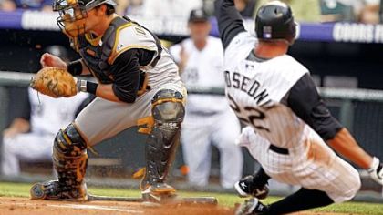 Colorado's Scott Podsednik scores the first run in the Rockies' five-run first inning, beating the throw to catcher Ryan Doumit.