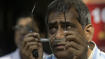MUMBAI, India --A man watchs the screen on the facade of Bombay Stock Exchange building. The BSE benchmark Sensex surged 804 points to close at 11,332 level.