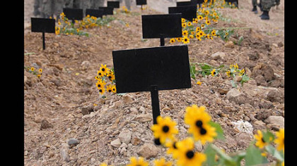 TBILISI, Georgia -- During a funeral ceremony outside of Tbilisi, makeshift grave markers rise above the mass grave of Georgian soldiers killed during the conflict with Russia. E.U. leaders stepped back from imposing sanctions over Russia's partial occupation of neighboring Georgia.