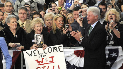 Democratic committee members Judith Fisher, left, and Madge Finney and  Julie Arbore, right, listen former President Bill Clinton addressing a crowd.