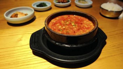 Tofu stew, a traditional Korean dish, is surrounded by a variety of banchan, side dishes that accompany meals at Korea Garden.