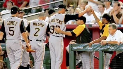 Jeff Karstens, center, is welcomed back to the dugout at the end of the bottom of the eighth inning == moments after he lost his no-hit and perfect-game bid at Chase Field.