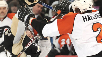 Penguins Petr Sykora takes a puck and stick from Flyers Derian Hatcher.