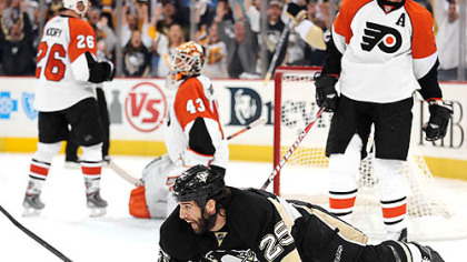 Penguins Max Talbot is knocked to the ice after scoring the winning goal.
