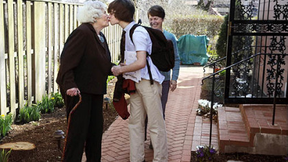 Dr. Ann Baldwin Taylor gets a back-from-school kiss from her grandson Neal, 14. His mother, Kate Golightly, stands behind him.
