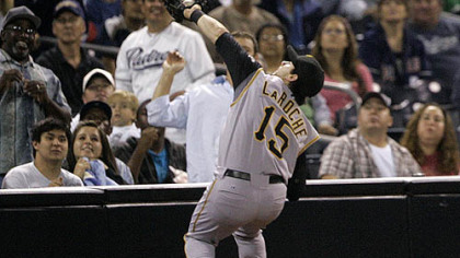 Pirates' Andy LaRoche leans over the seats to catch a pop foul hit by the Padres' Adrian Gonzalez last night in San Diego.