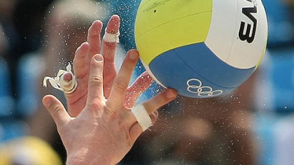Sand and ball fly during the men's beach volleyball match between Brazil and Austria. Austria won 2-1.