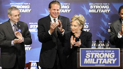 On stage with, from left, retired Gen. Michael Dunn, retired Adm. David Stone and retired Gen. John Watkins, Sen. Hillary Rodham Clinton applauds the crowd at Hopewell High School yesterday.